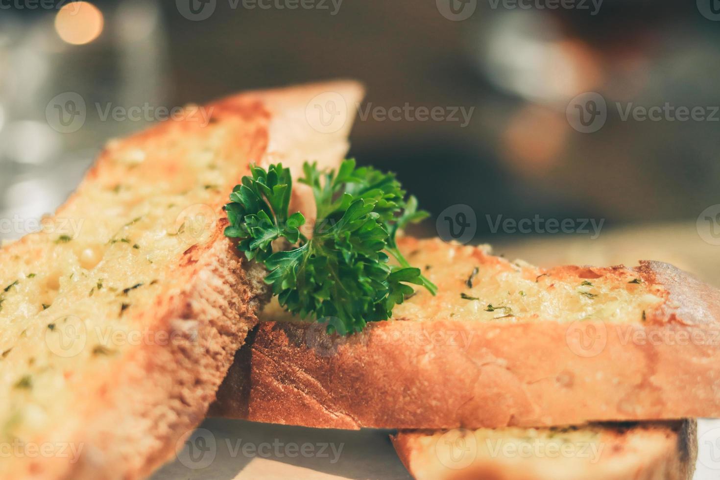 Close up Freshly baked garlic bread on wood plate. photo