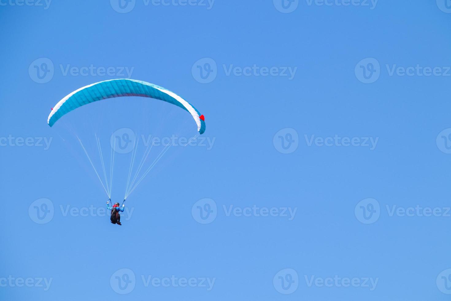 Paraglider soaring in the blue sky. photo