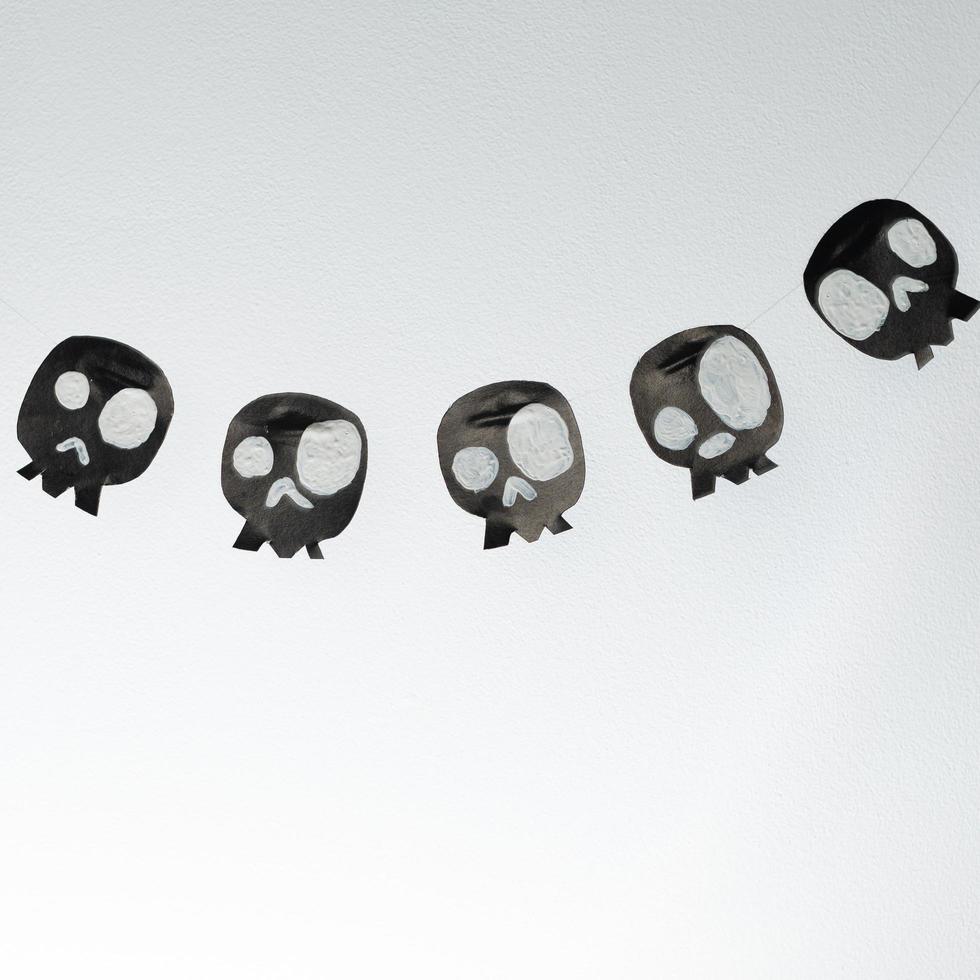 Skulls cut out of black paper on a white background, preparation for Halloween. photo