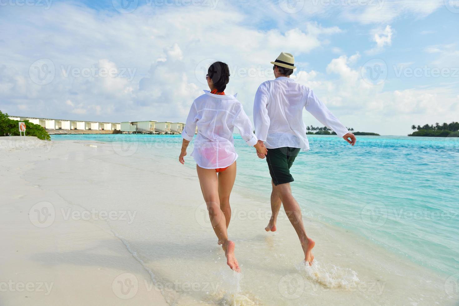 happy young couple have fun on beach photo
