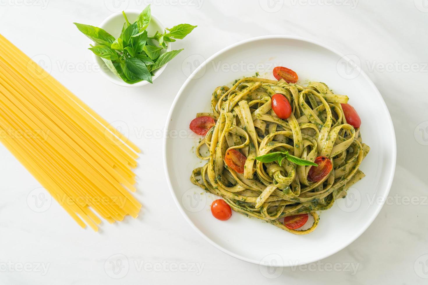 fettuccine spaghetti pasta with pesto sauce and tomatoes photo