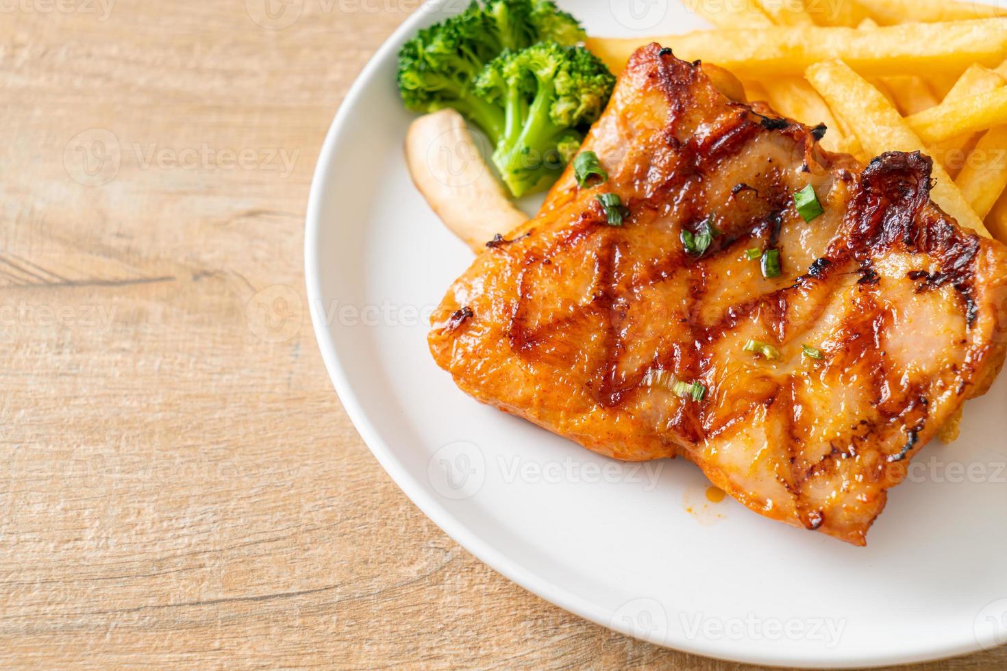 grilled chicken steak with potato chips or french fries photo