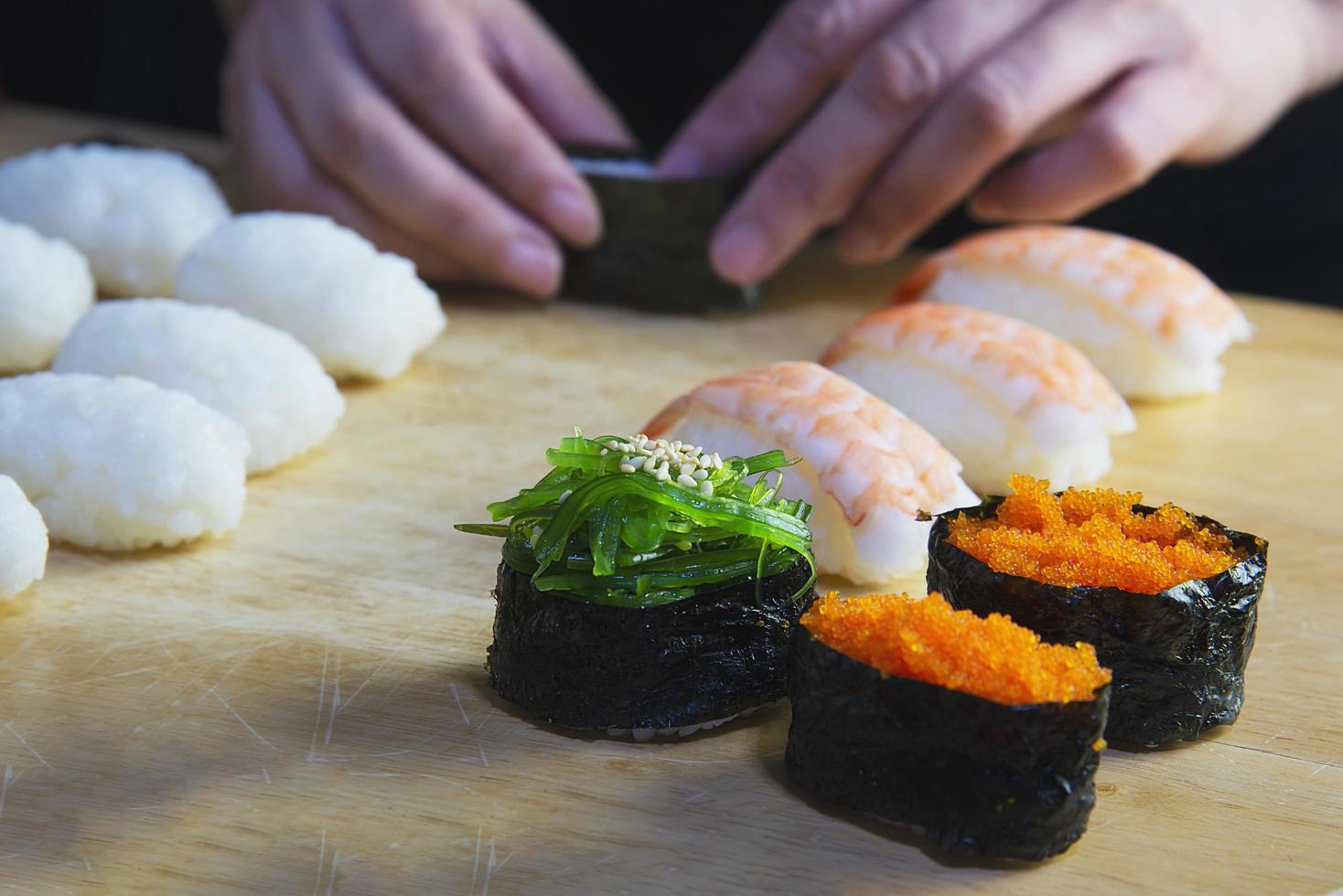 Rollo de sushi maki japonés que sirve en un restaurante oriental, el chef está preparando el menú de cocina tradicional de Japón, varios diferentes conceptos variados de comida saludable mixta de lujo foto