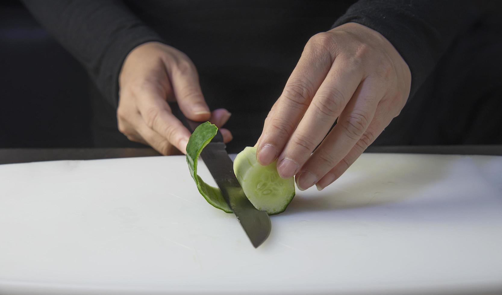 el chef está preparando pepino fresco para hacer el menú de cocina tradicional de Japón, rollo de sushi maki japonés que se sirve en un restaurante oriental, varios conceptos variados de comida saludable mezclada de lujo foto