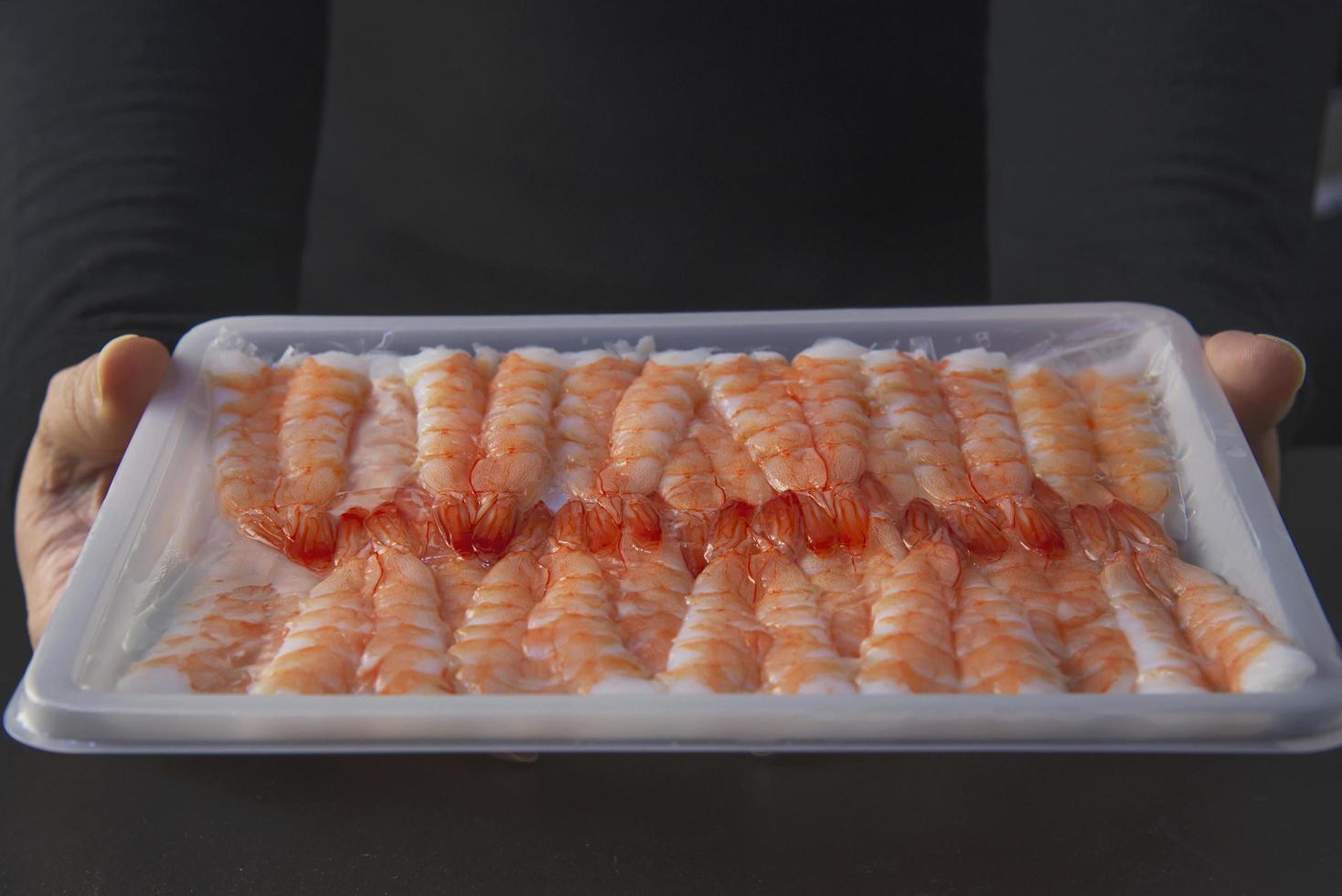 el chef está preparando camarones de sushi para hacer un menú de cocina japonesa, un rollo de sushi maki japonés que sirve en un restaurante oriental, varios conceptos variados de comida saludable mezclada de lujo foto