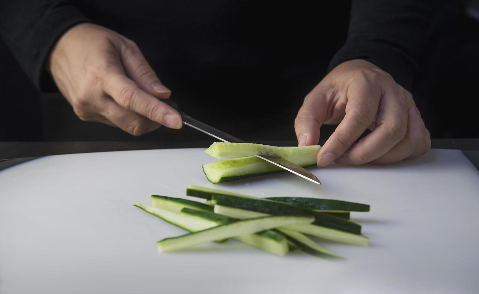 el chef está preparando pepino fresco para hacer el menú de cocina tradicional de Japón, rollo de sushi maki japonés que se sirve en un restaurante oriental, varios conceptos variados de comida saludable mezclada de lujo foto