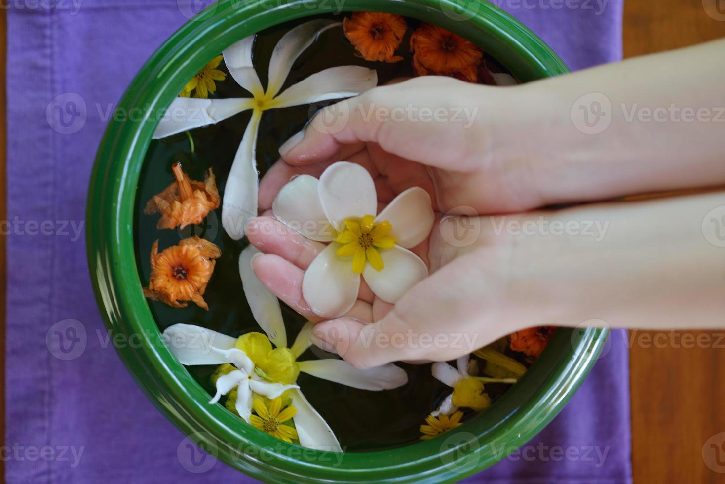 mano femenina y flor en agua foto