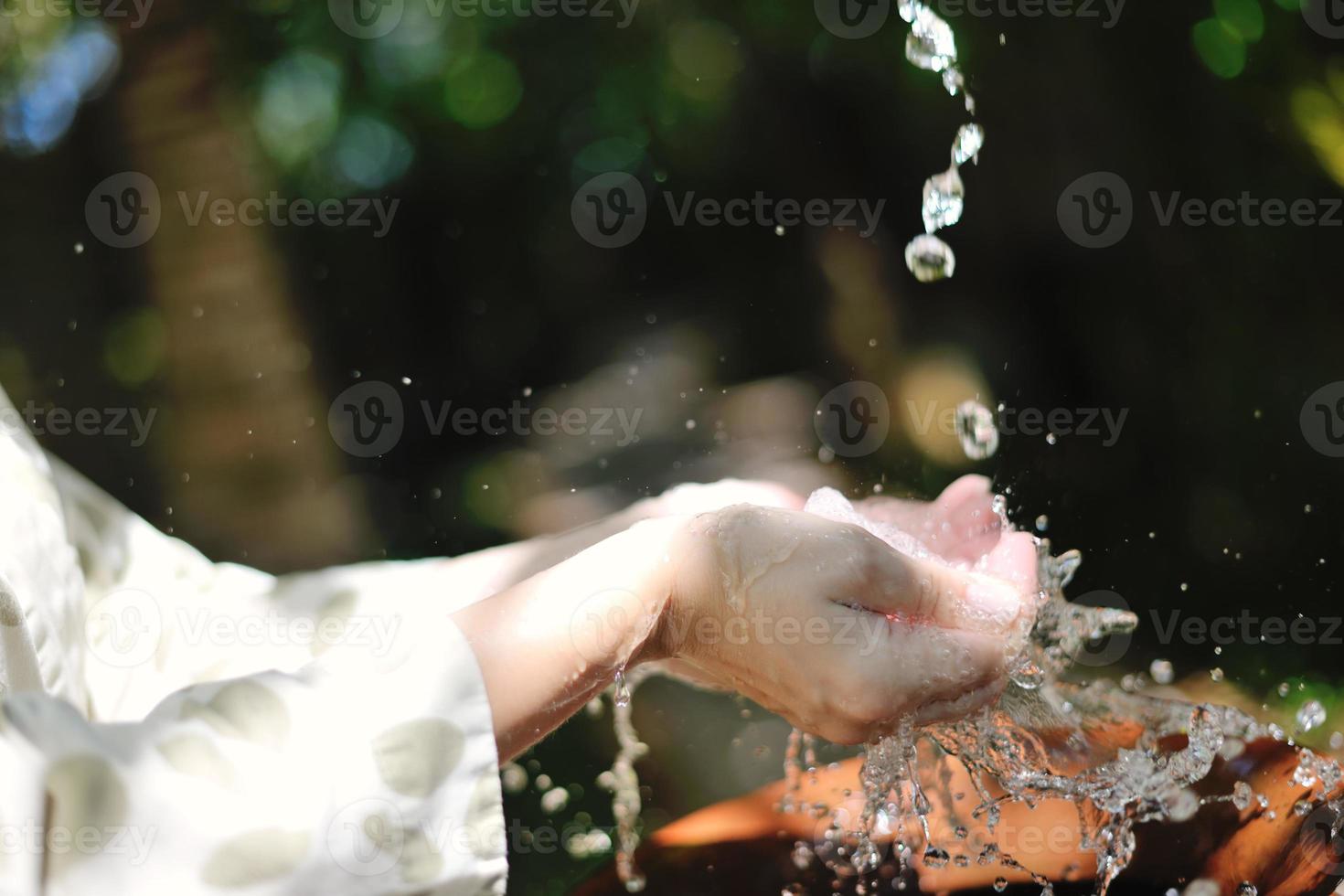 splashing fresh water on woman hands photo