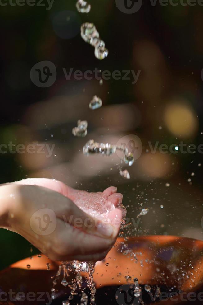 splashing fresh water on woman hands photo