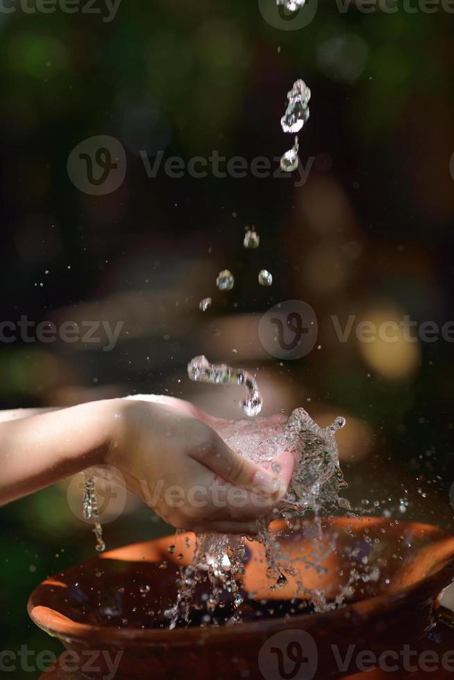 salpicando agua dulce en manos de mujer foto