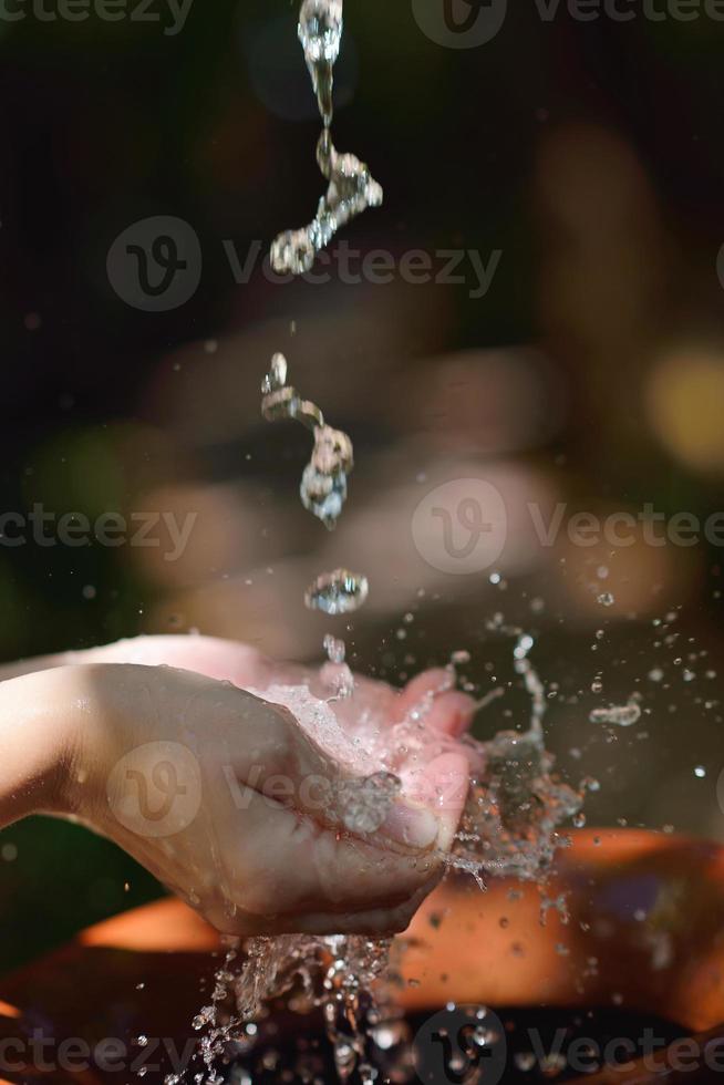 splashing fresh water on woman hands photo