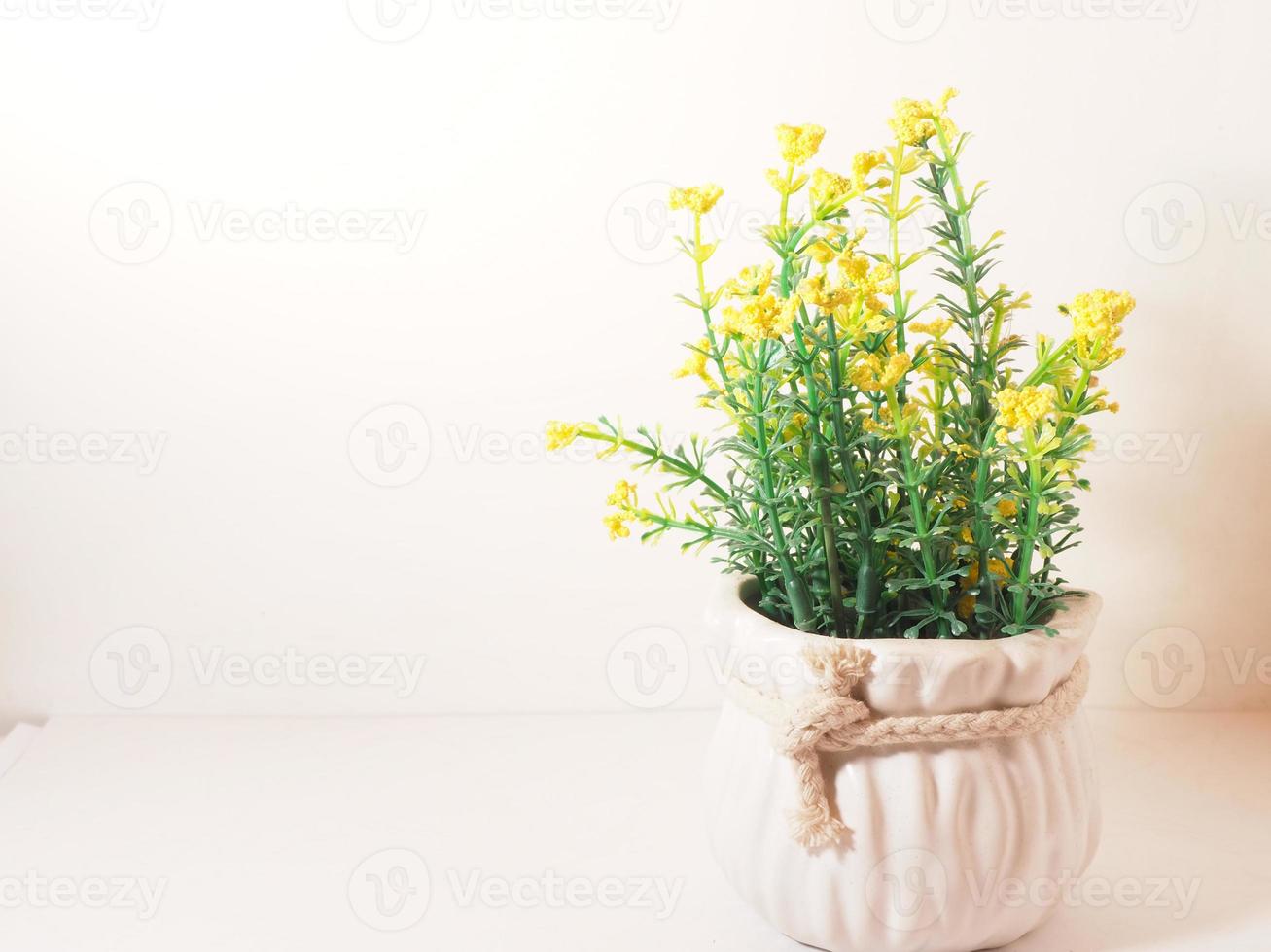 imagen de una flor de plástico artificial en un jarrón de cerámica foto