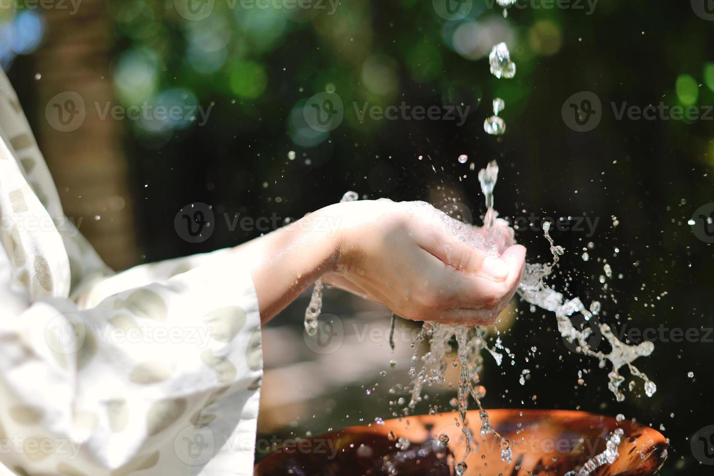 salpicando agua dulce en manos de mujer foto