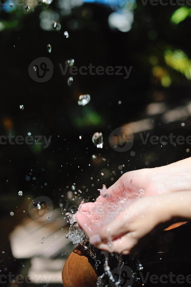 splashing fresh water on woman hands photo