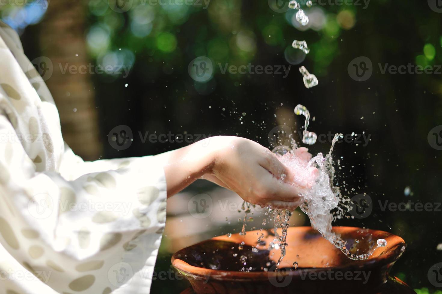 salpicando agua dulce en manos de mujer foto