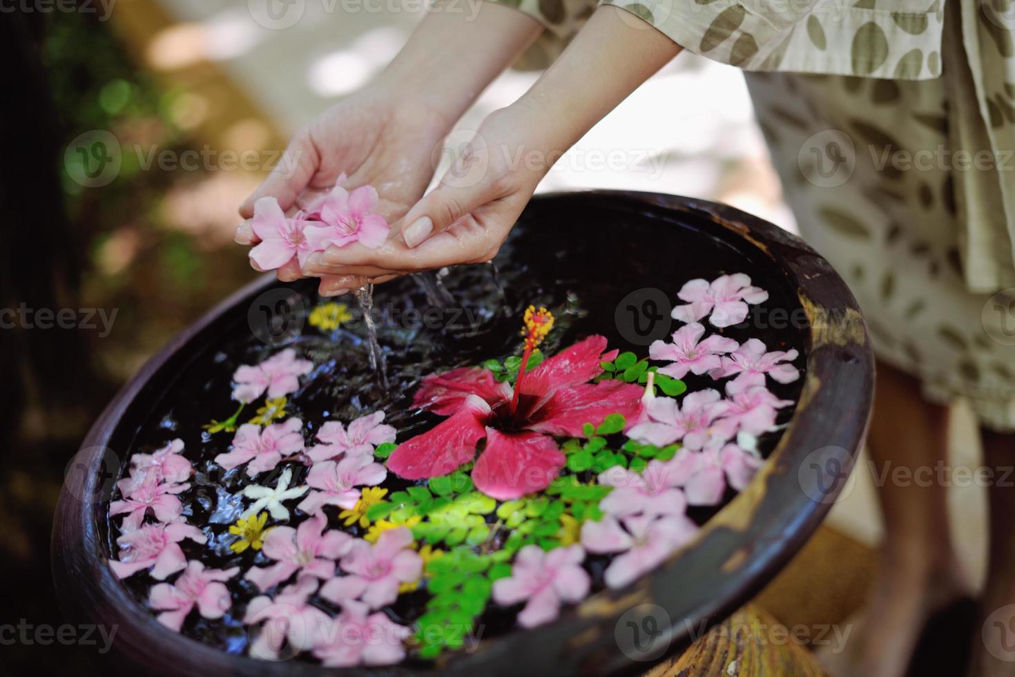 mano femenina y flor en agua foto