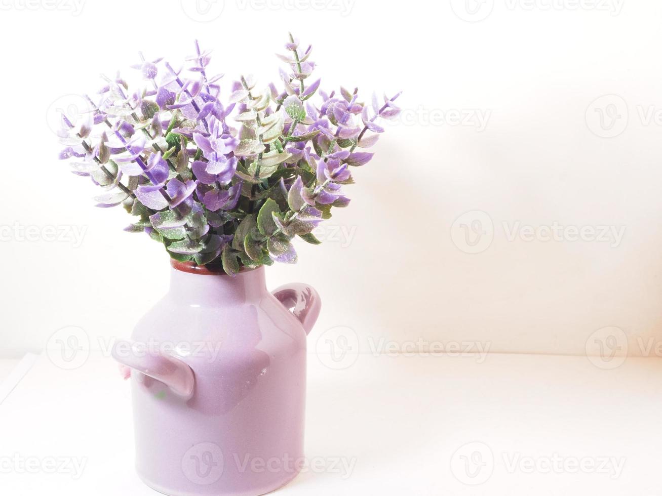 imagen de una flor de plástico artificial en un jarrón de cerámica foto