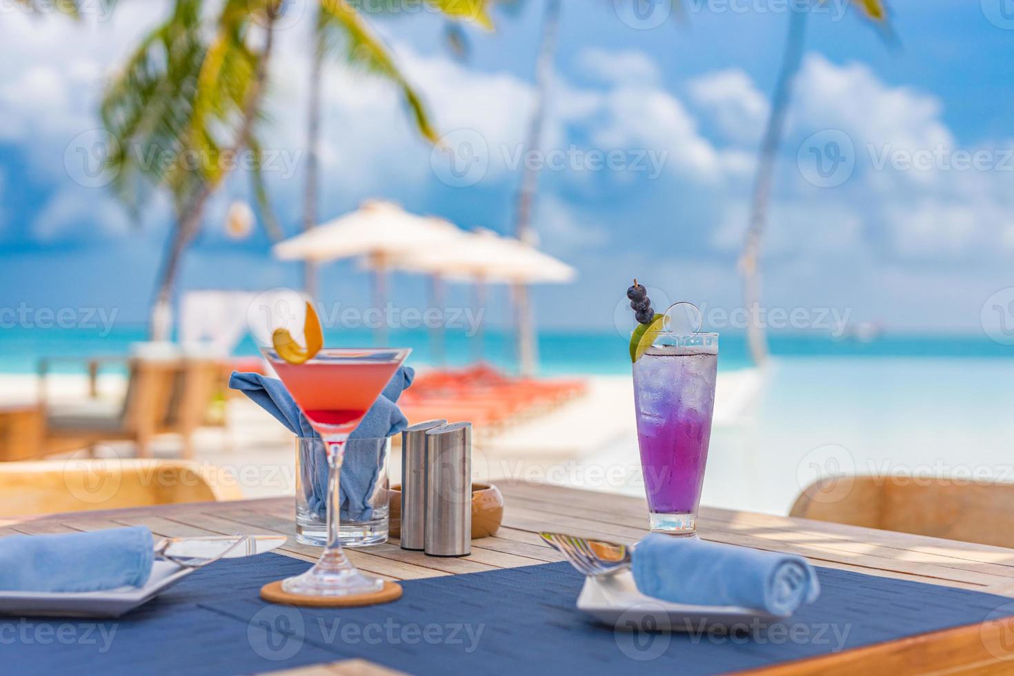 primer plano de la mesa de la mañana, palmeras, cócteles en la piscina infinita en un hotel de lujo junto a la piscina, restaurante al aire libre, playa, océano y cielo, café de la isla tropical. vacaciones de verano o vacaciones, viajes familiares. foto