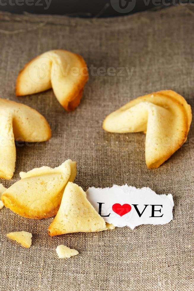 galletas con forma de tortellini con la palabra amor escrita en una imagen de papel.vertical. foto