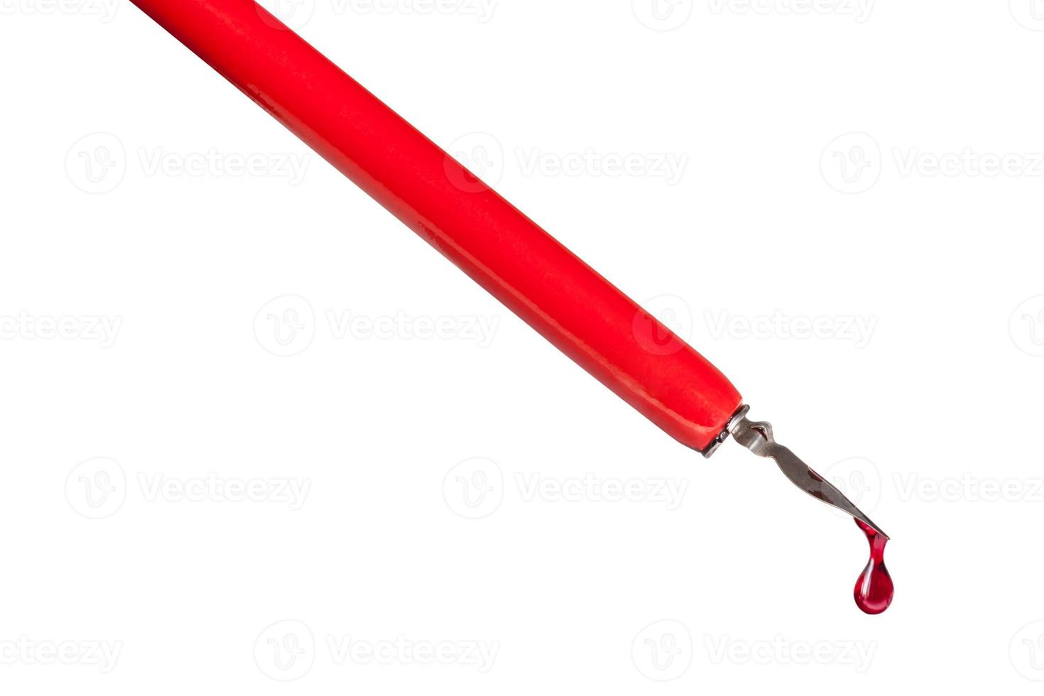 ink drop dripping from tip of nib of red dip pen photo
