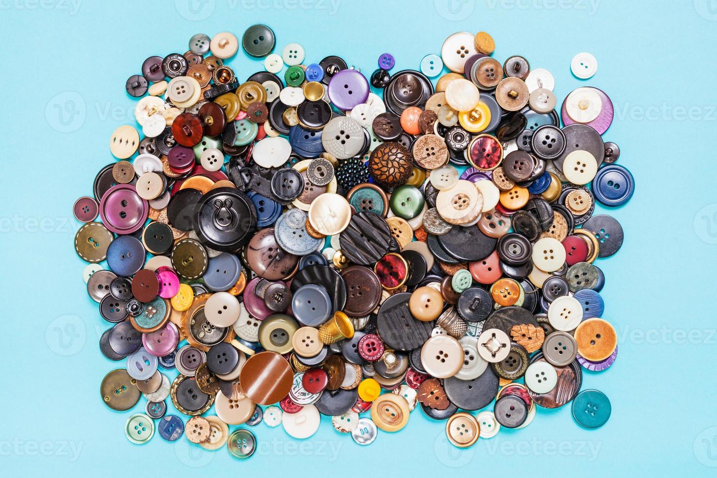 heap of many various buttons on blue background photo