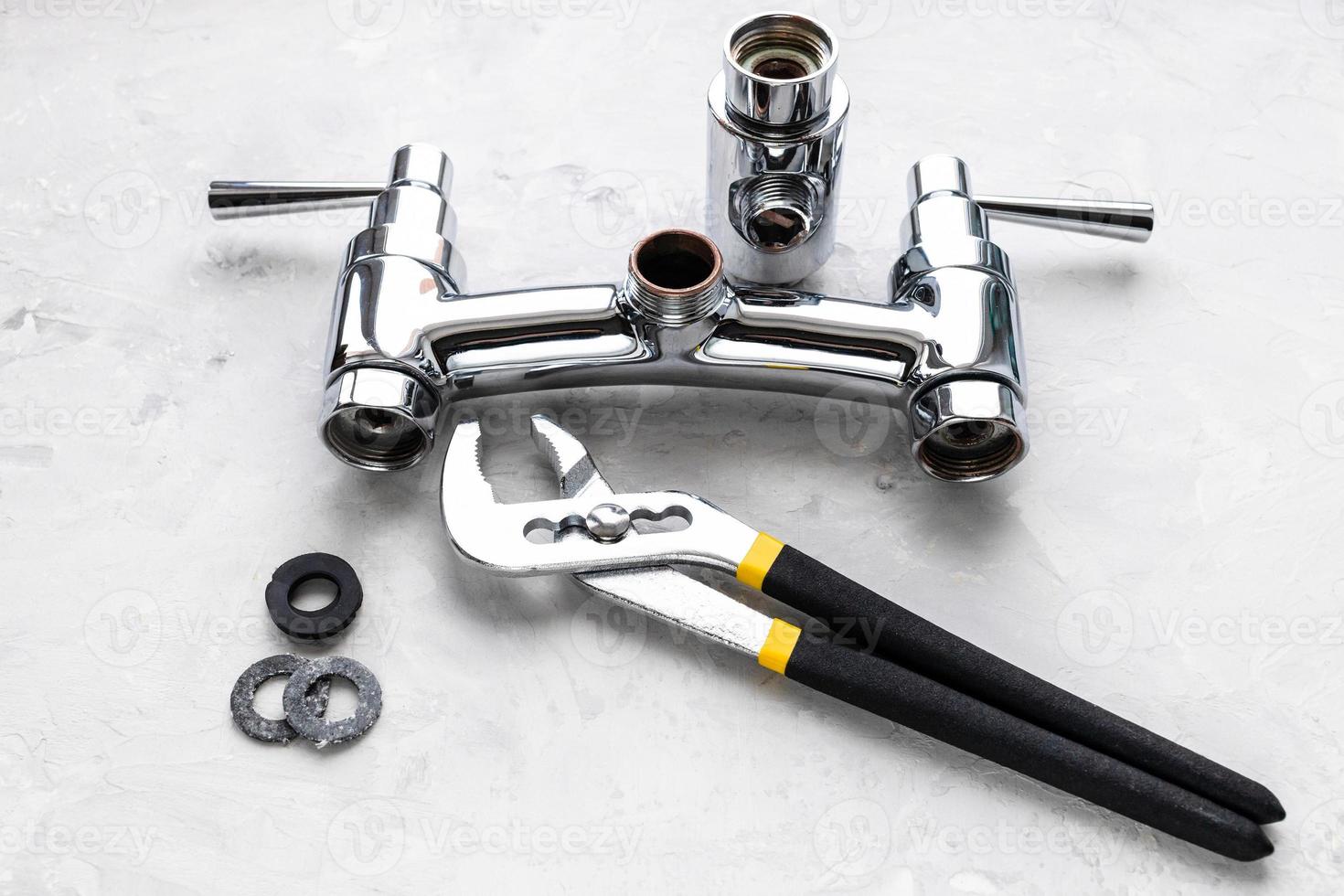 wrench, gaskets near disassembled shower faucet photo