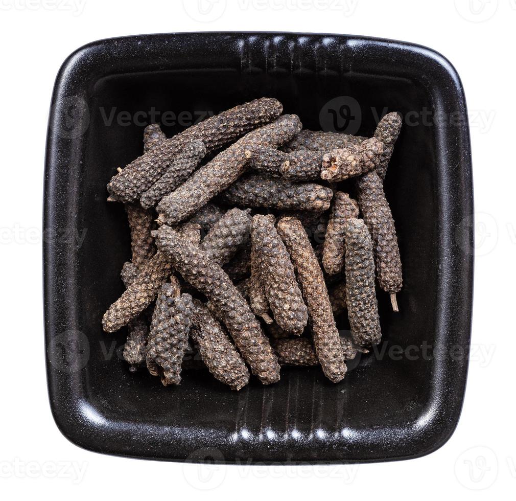 top view of java long pepper in bowl isolated photo