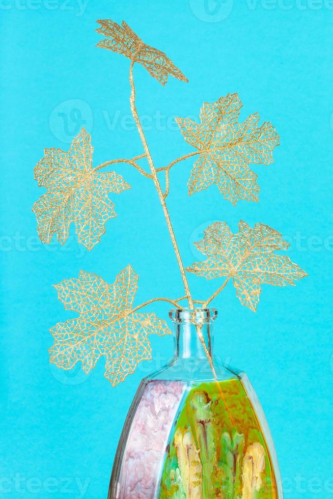 artificial twig of tree in handpainted bottle photo