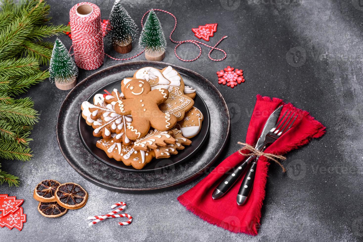 pan de jengibre, adornos de árboles de Navidad, cítricos secos sobre un fondo de hormigón gris foto