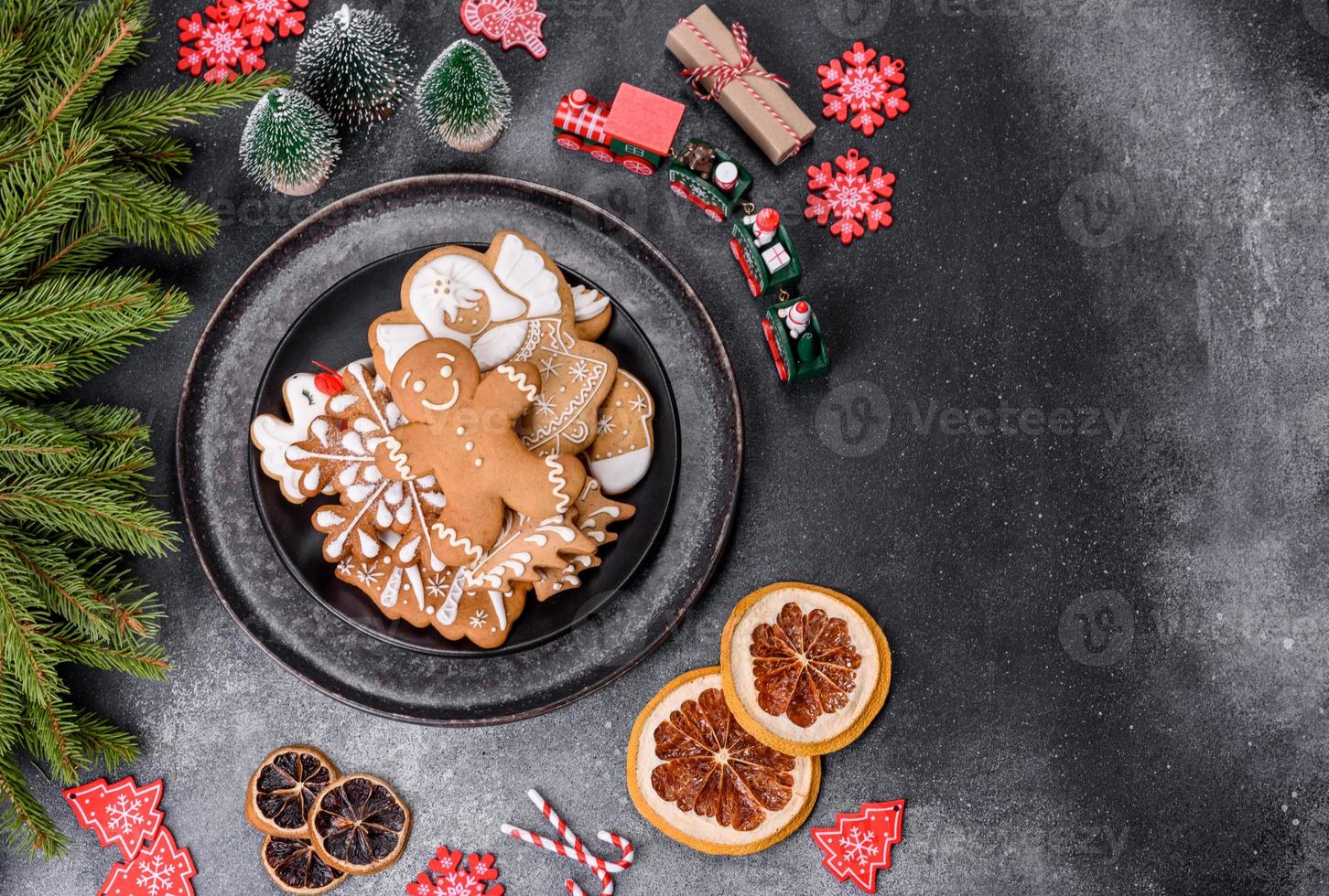 pan de jengibre, adornos de árboles de Navidad, cítricos secos sobre un fondo de hormigón gris foto
