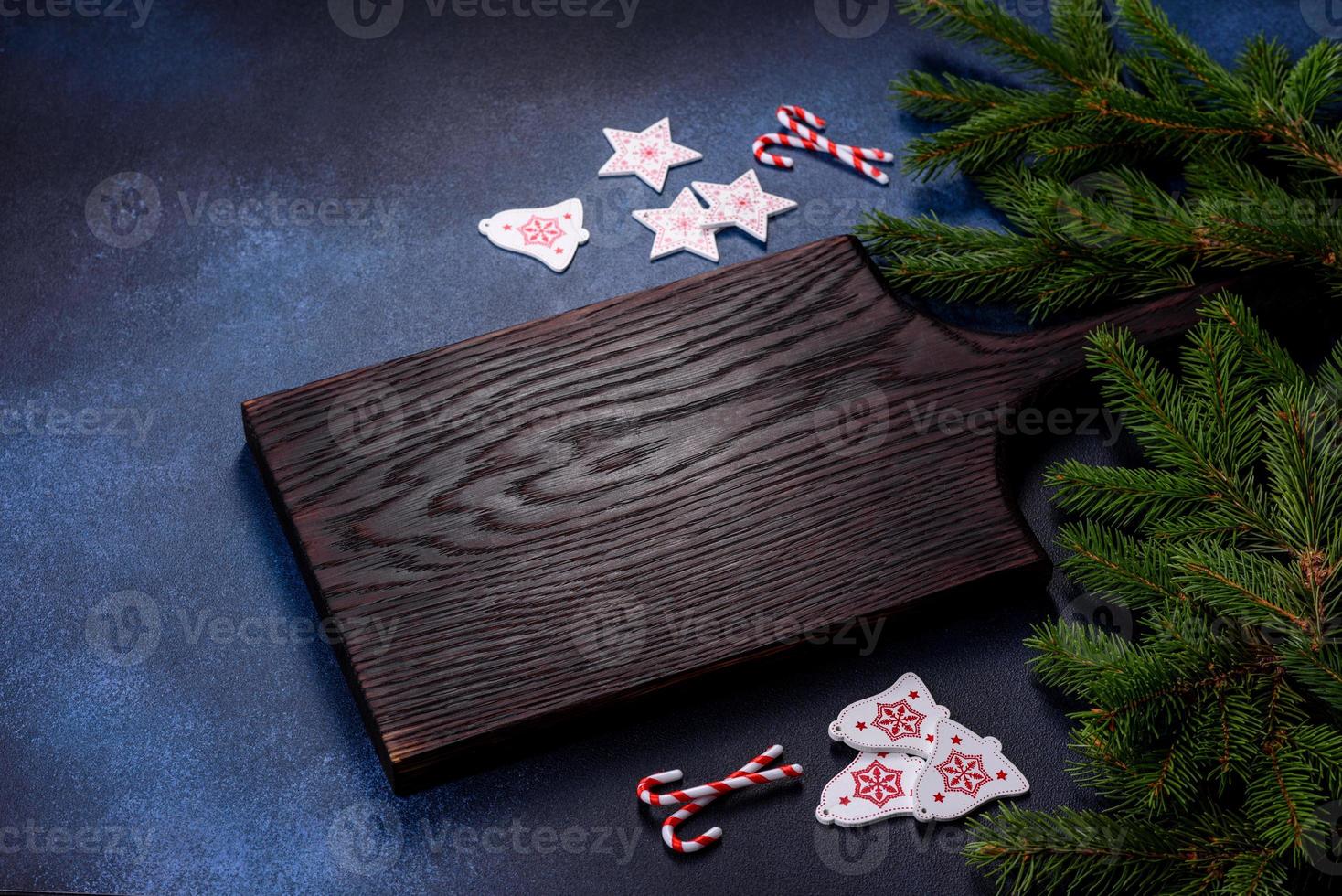 tabla de cortar de madera con dulces navideños y decoraciones foto