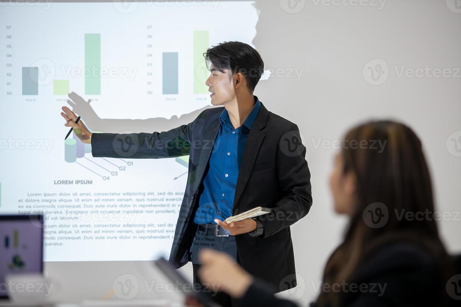 Asian business team male and female colleagues talking at work share ideas with chart on board, Happy young presentation colleagues work together on board. photo