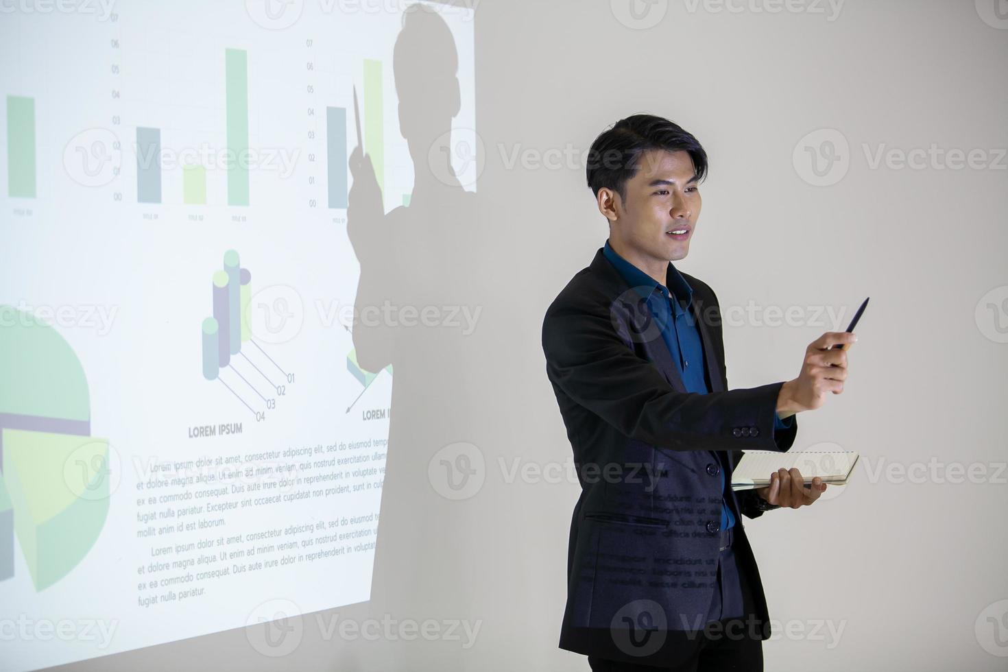 los colegas masculinos y femeninos del equipo de negocios asiático que hablan en el trabajo comparten ideas con el gráfico a bordo, los colegas jóvenes felices de presentación trabajan juntos a bordo. foto