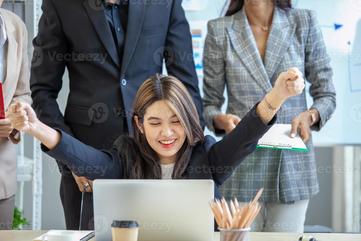 Asian business team celebrate corporate victory together in office, laughing and rejoicing, smiling excited employees colleagues screaming with joy in office. photo