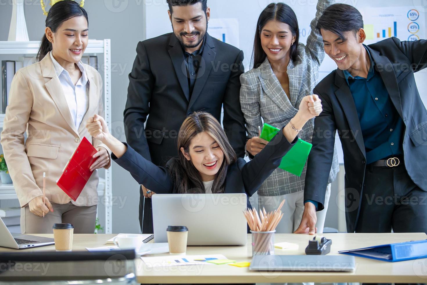 Asian business team celebrate corporate victory together in office, laughing and rejoicing, smiling excited employees colleagues screaming with joy in office. photo