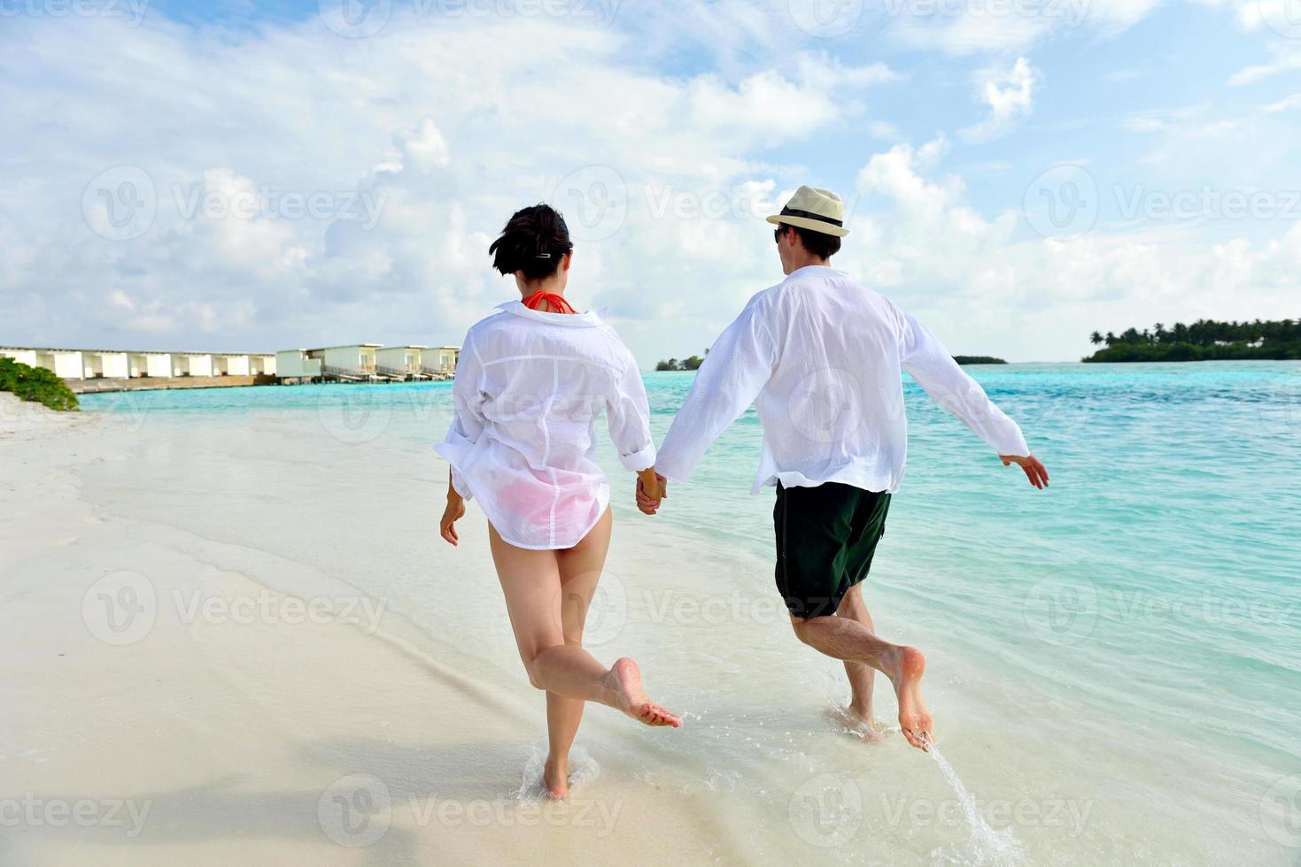 happy young couple have fun on beach photo