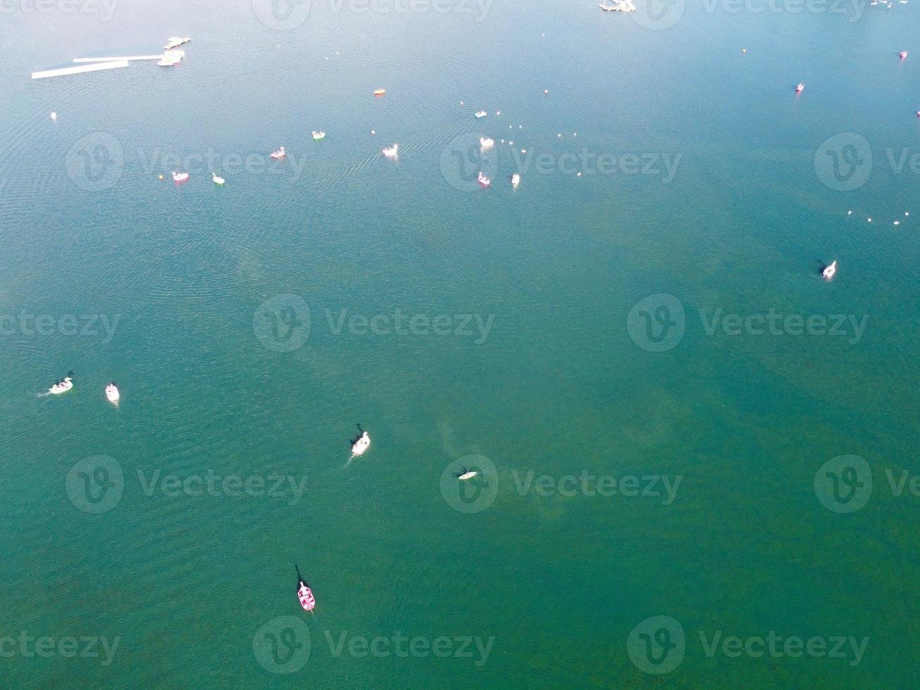 Beautiful Aerial Drone's Camera  Footage of Willen Lake and Park which is located at Milton Keynes, England. People are Enjoying at Lake on a Hot Sunny Day of Summer photo