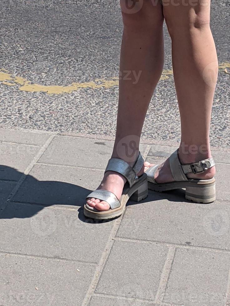 Female legs in sandals. Summer street fashion. photo