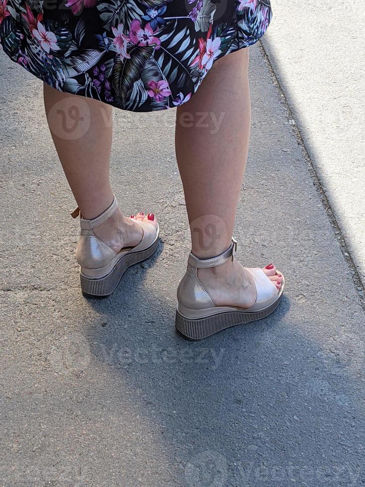 Female legs in sandals. Summer street fashion. photo