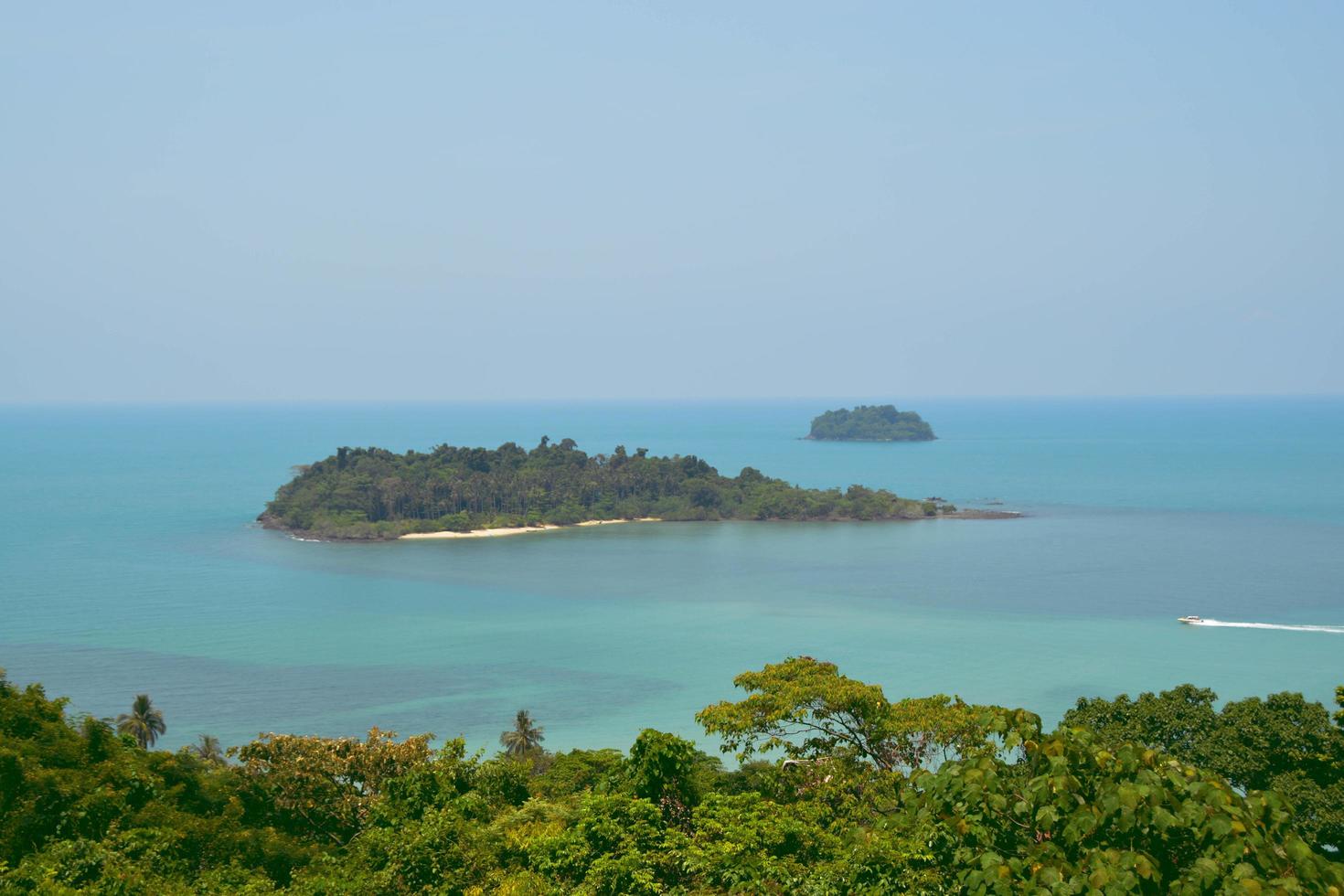 Beautiful landscapes island on the blue sea and speed boat drive through the island. Snap shot on the other side of the island. photo