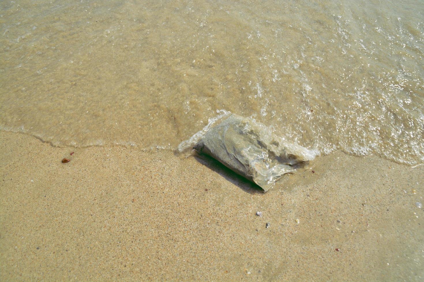 arena en bolsa de plástico en el mar foto