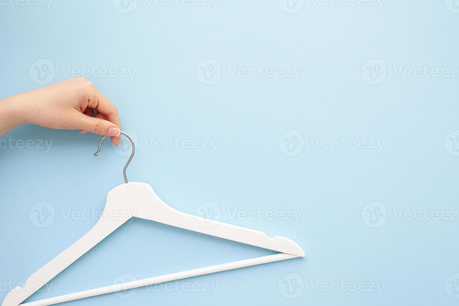 White wooden hangers on blue background photo