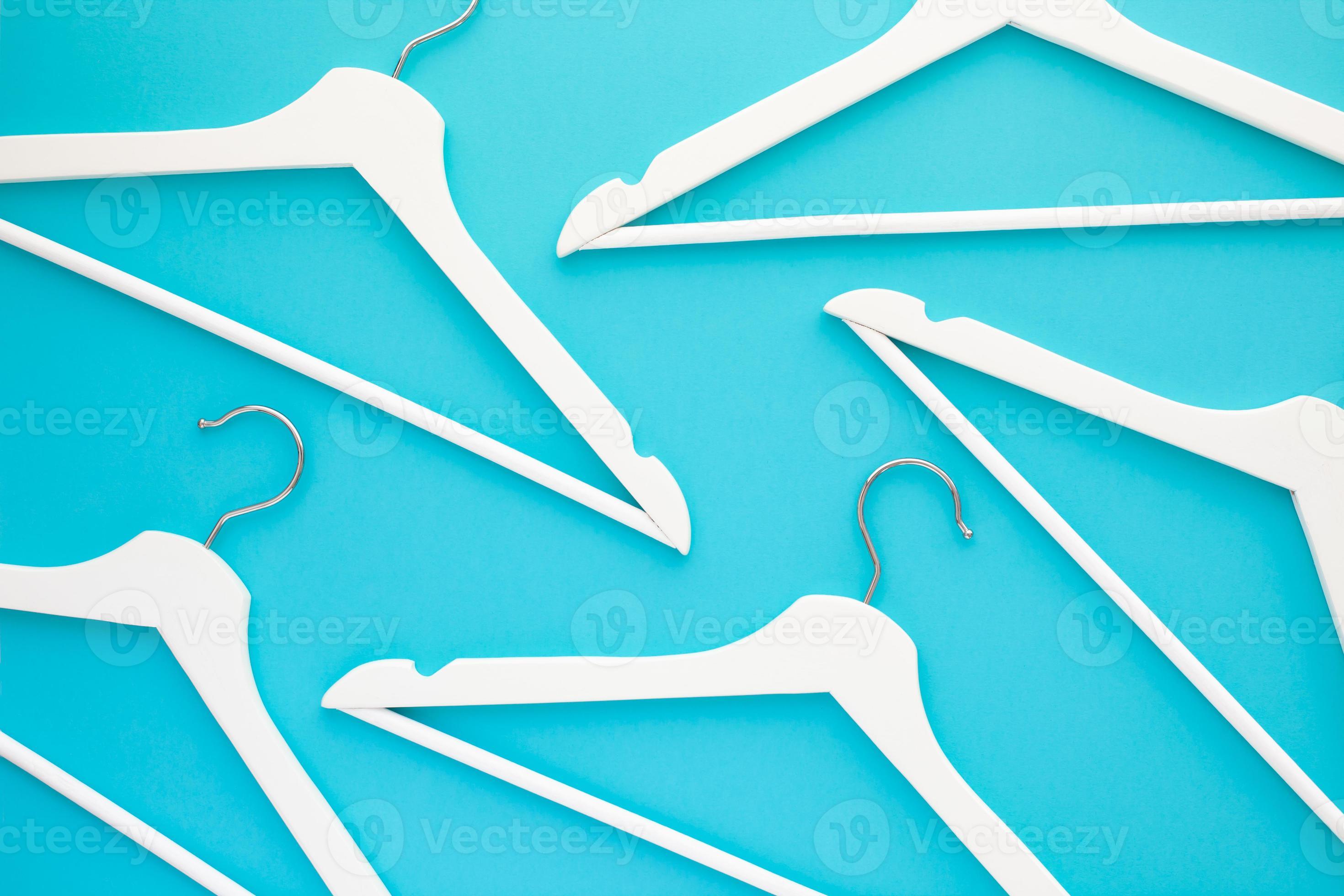 White wooden hangers on blue background 10770158 Stock Photo at Vecteezy