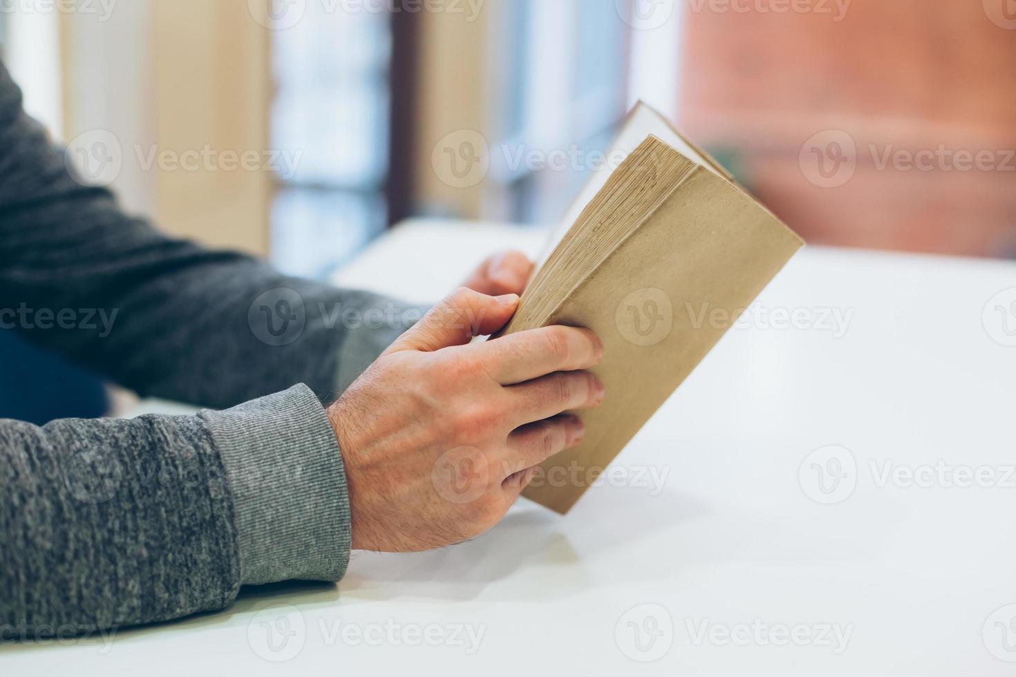 Young man reading open old paper book photo