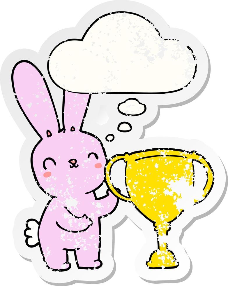 cute cartoon rabbit with sports trophy cup and thought bubble as a distressed worn sticker vector