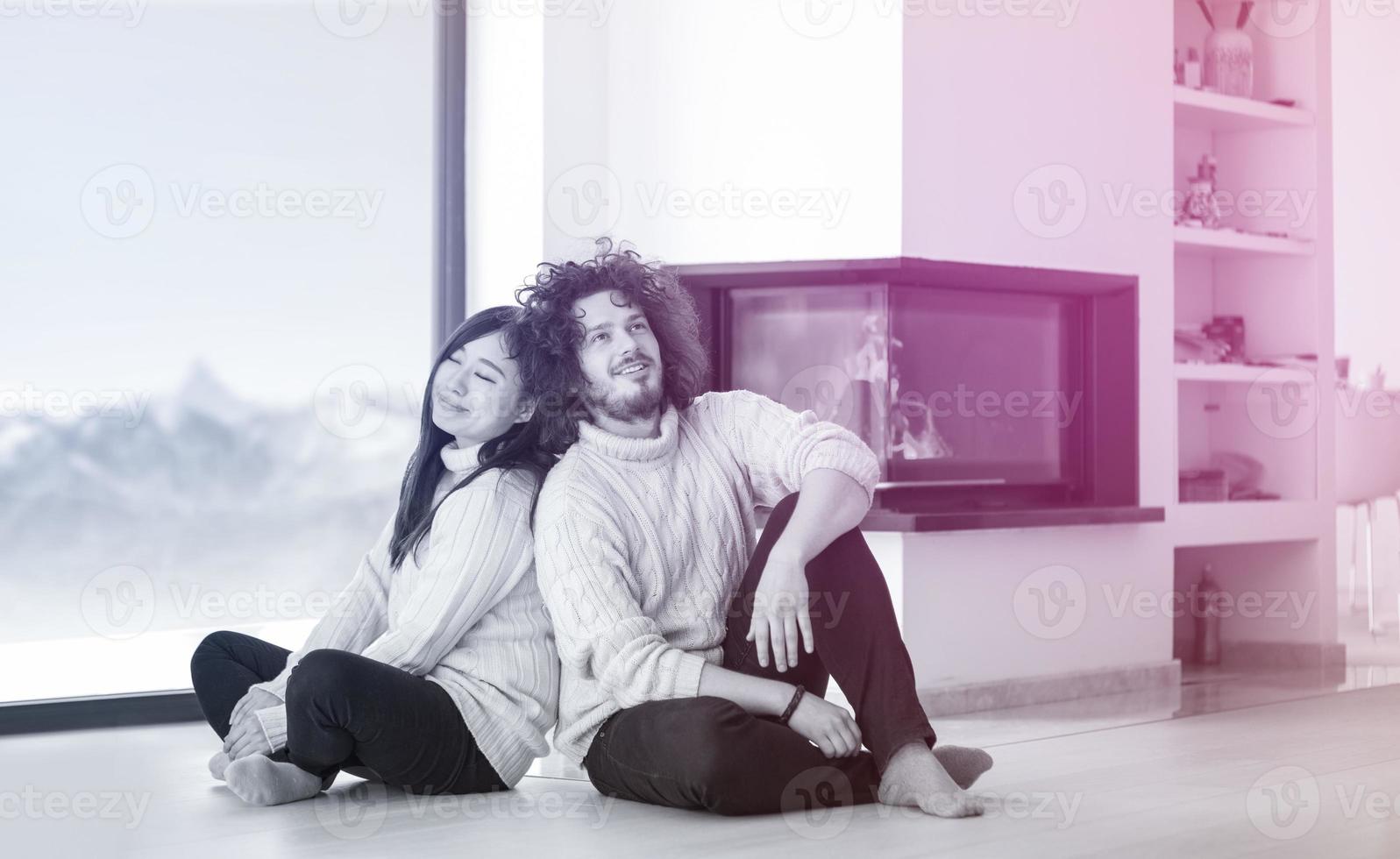 happy multiethnic couple  in front of fireplace photo