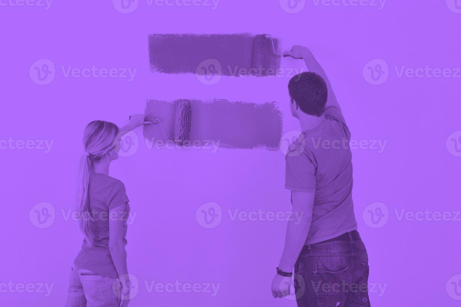 happy couple paint wall at new home photo