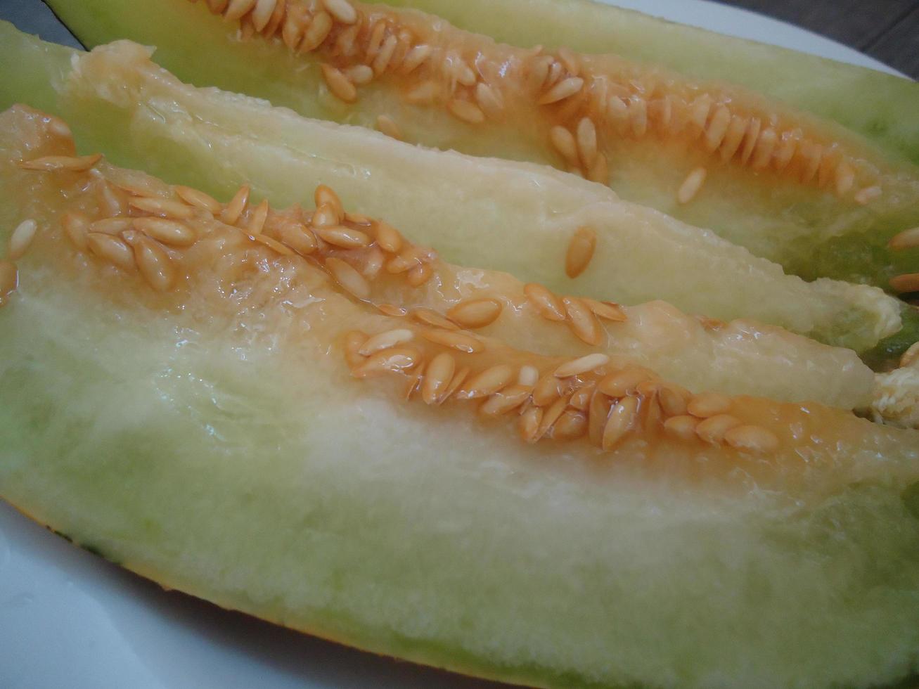 Varietal cut melon lies on a plate photo