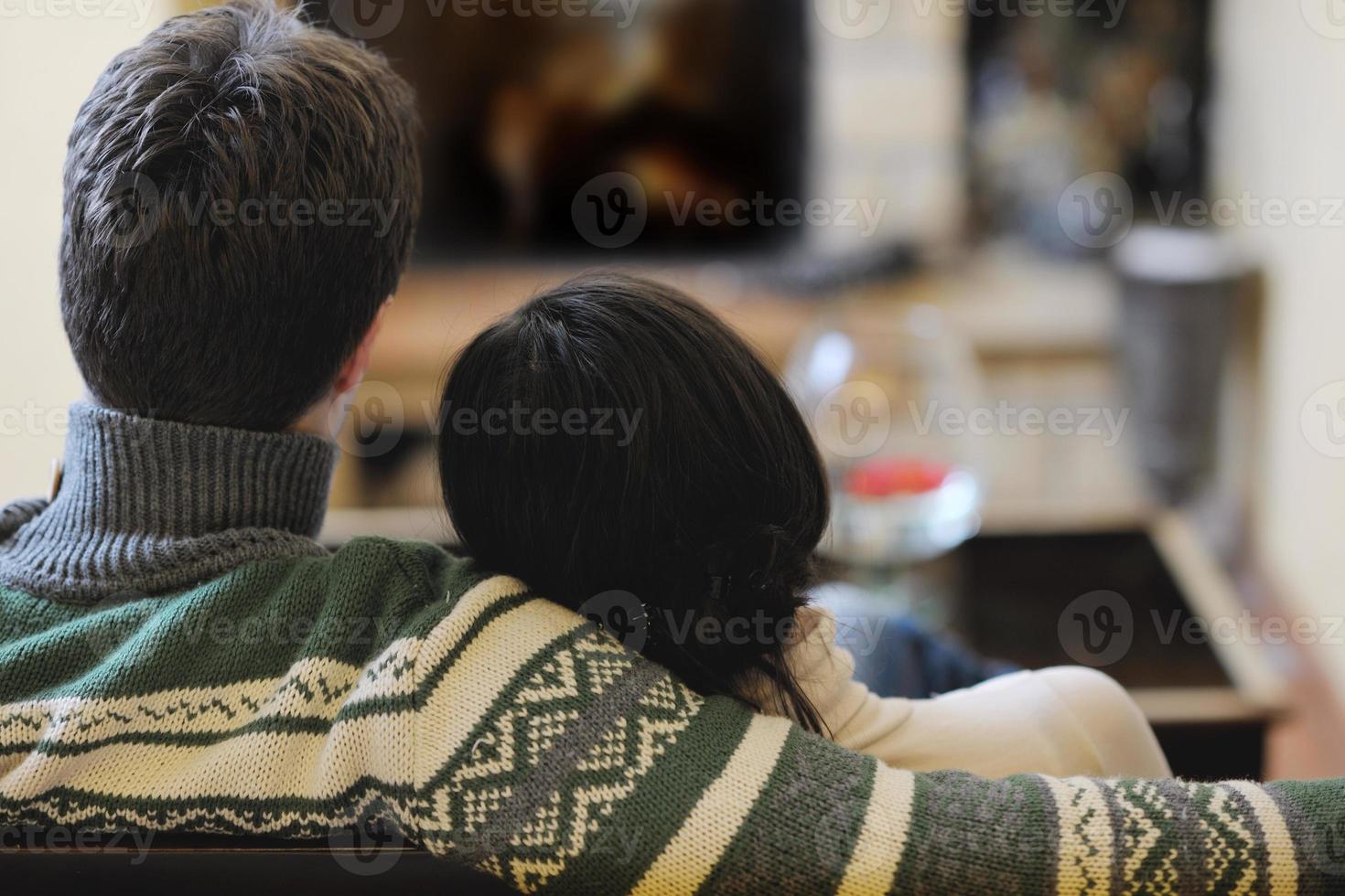 Young romantic couple sitting and relaxing in front of fireplace at home photo