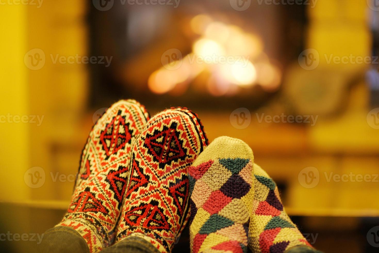 Young romantic couple sitting on sofa in front of fireplace at home photo